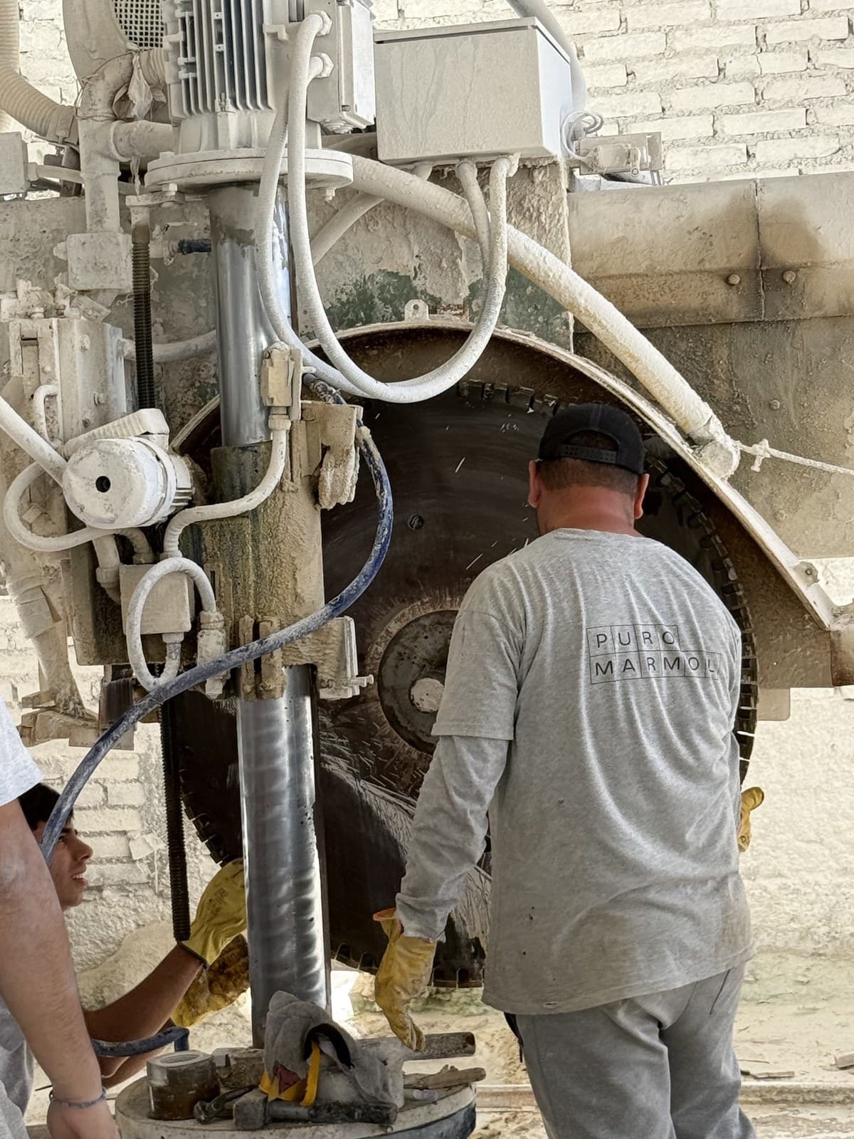 Operario de Puro Mármol trabajando en la cortadora de disco del taller