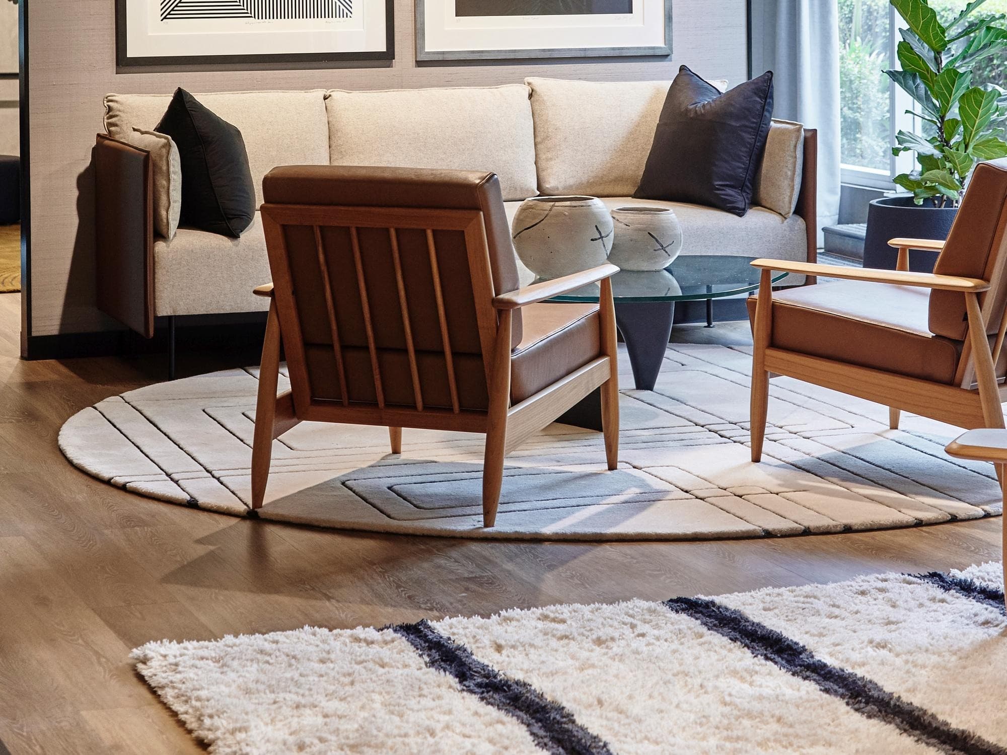 Living con una carpeta clara sobre piso de madera, butacas y sillón