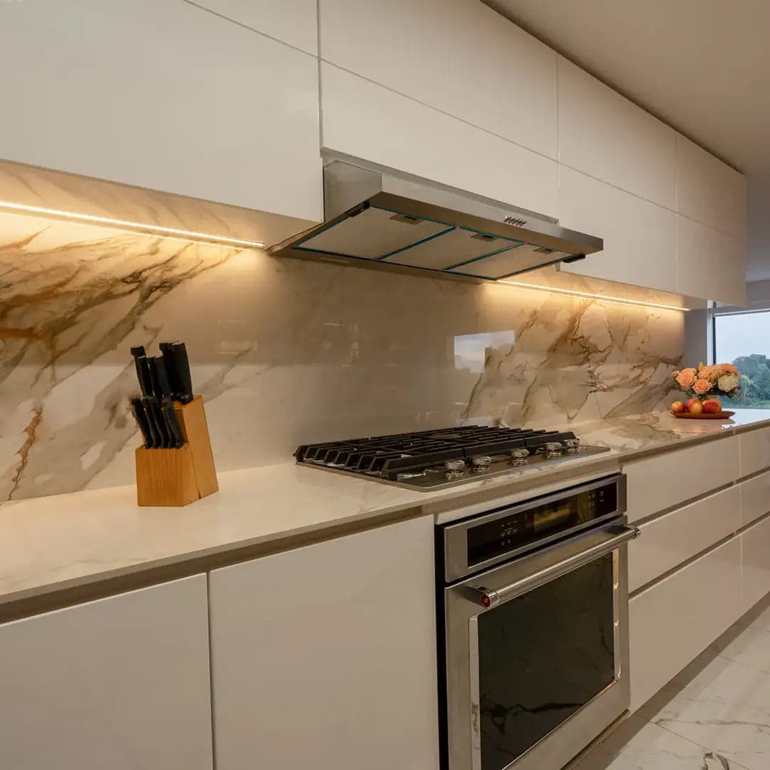 Cocina clara con horno empotrado y frente de piedra