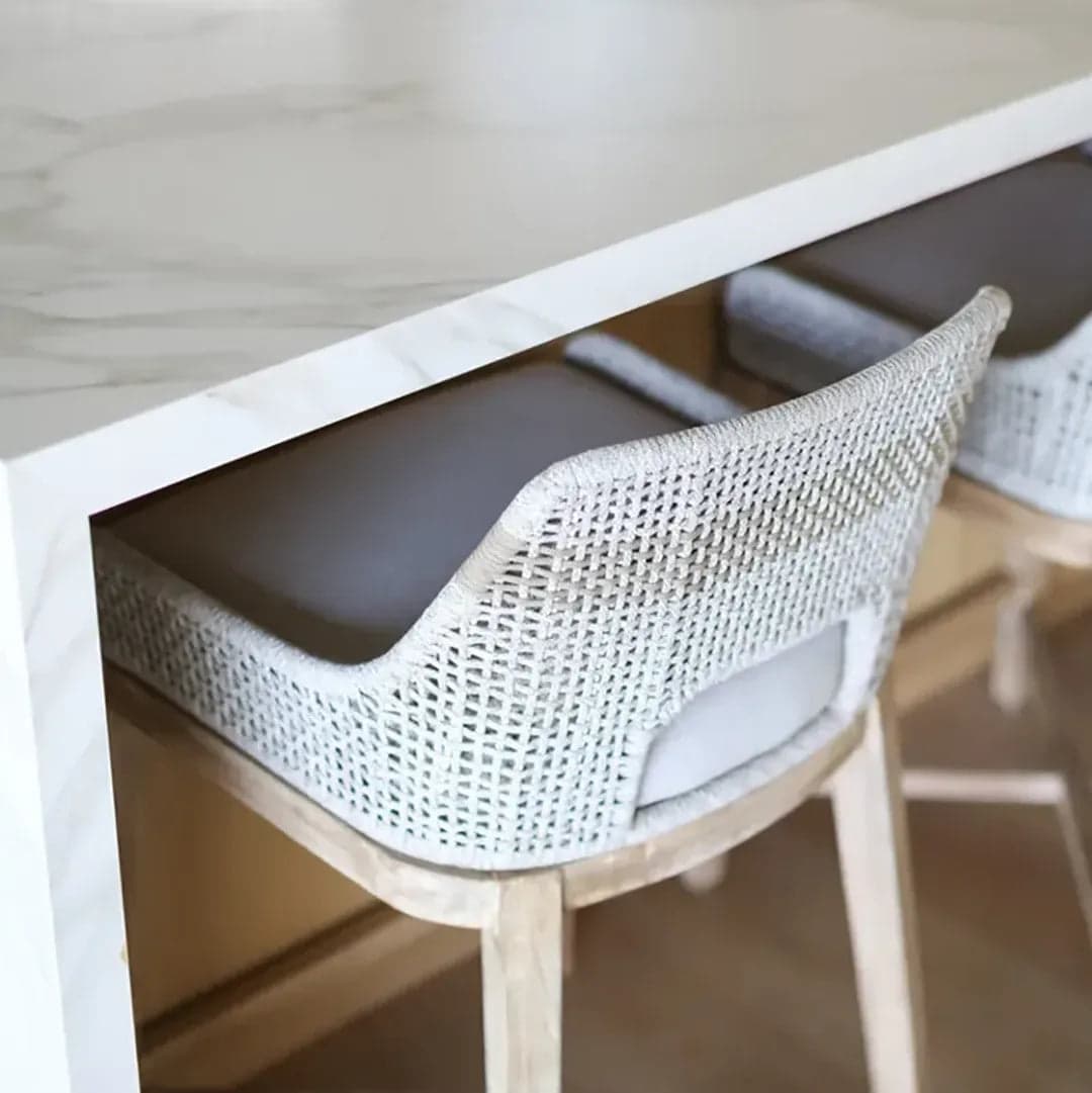 Silla de ratán junto a una mesa de mármol