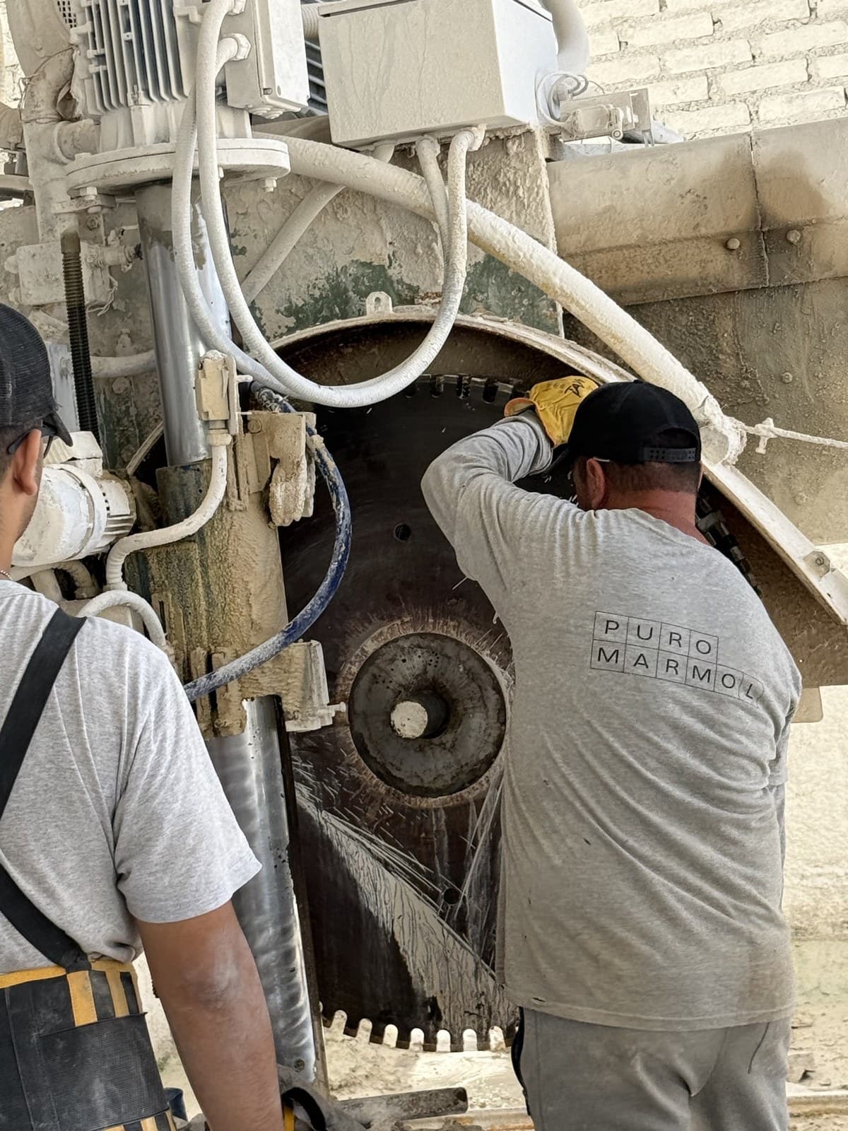 Dos operarios de Puro Mármol operando la cortadora de disco
