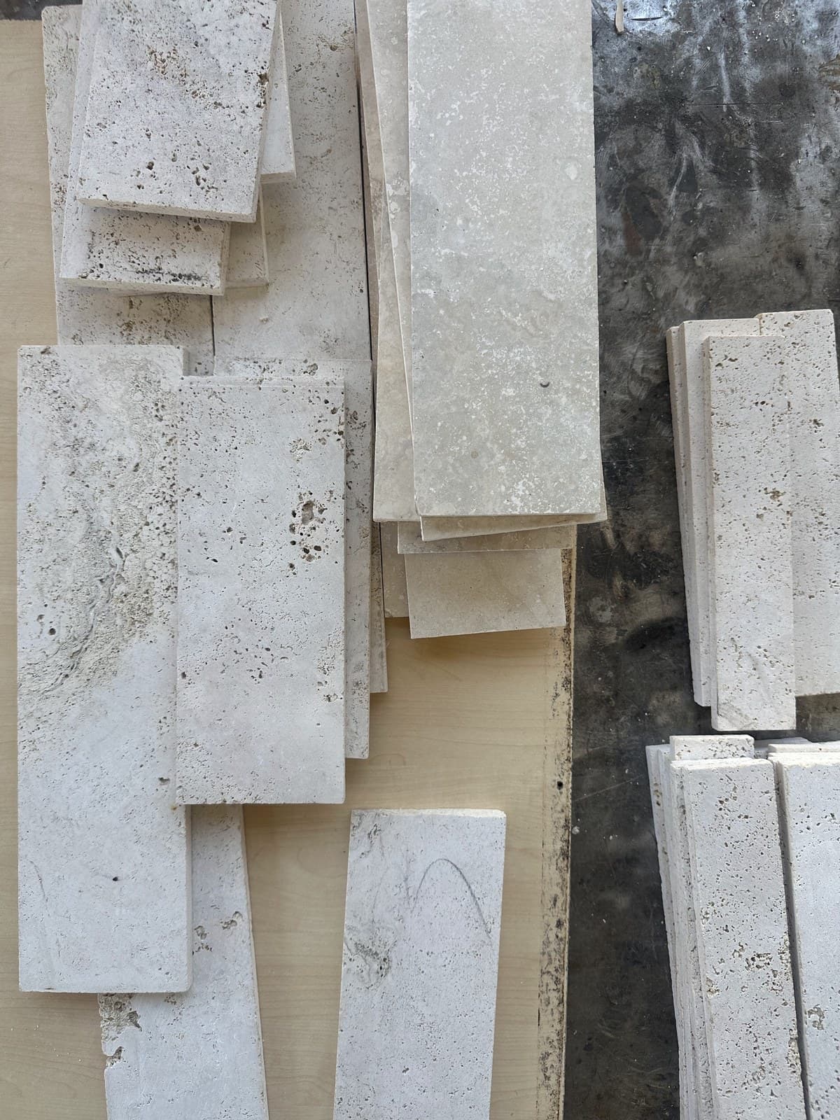 Piezas de travertino nacional cortadas y apoyadas contra la pared del taller