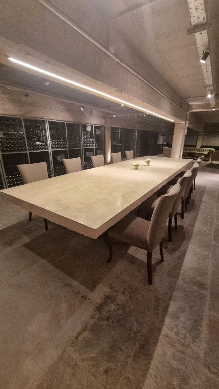 Bodega Chandon: mesa de degustación de piedra con los botelleros al fondo