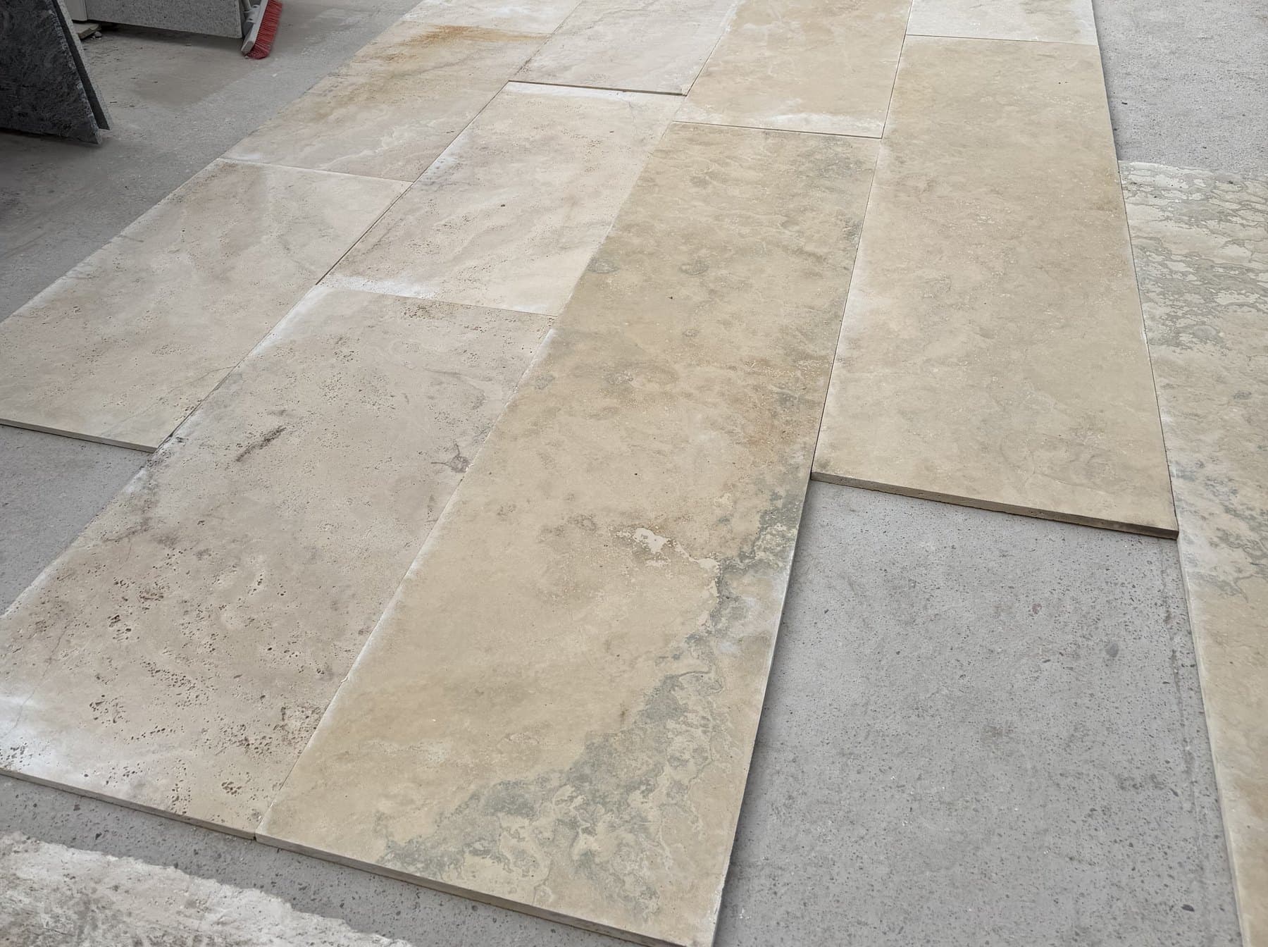 Placas de travertino de 60 cm por largo libre en el playón, junto a formatos más angostos